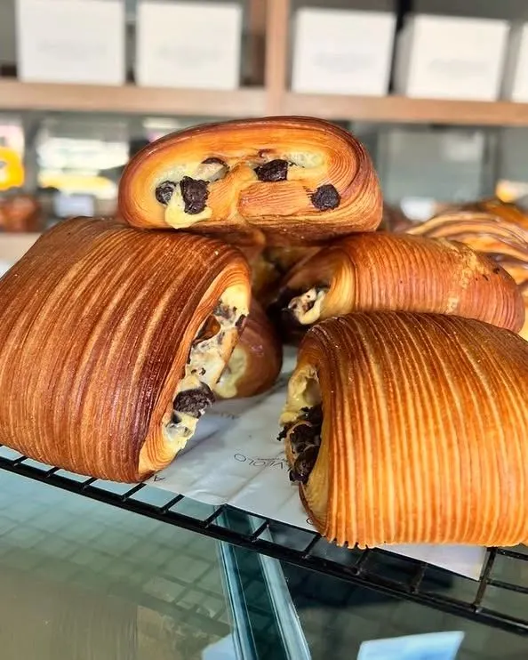 Piezas de hojaldre laminado, rellenas de chocolate, sobre la rejilla de la vitrina